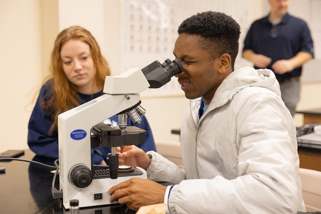 Student looking through a microscope